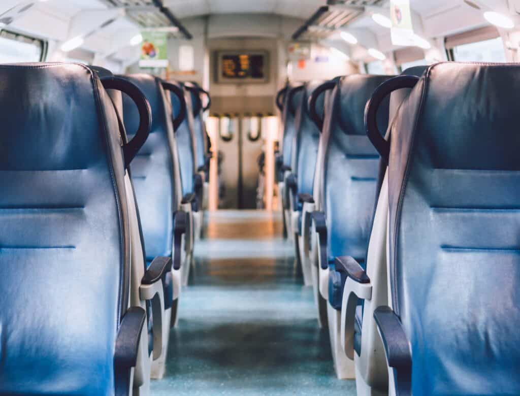 Rows of empty blue seats inside a train carriage, echoing the orderliness found in industrial material management systems.